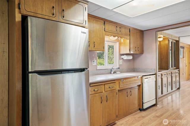 3180 Woodcock Rd, Sequim, WA 98382 - kitchen with freestanding refrigerator, dishwasher, light countertops, a sink, and light wood-type flooring