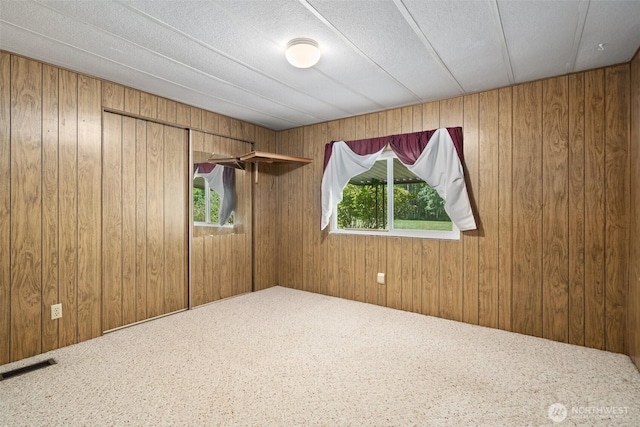 3180 Woodcock Rd, Sequim, WA 98382 - carpeted empty room featuring plenty of natural light and wooden walls