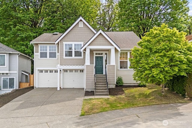 view of front of home with a garage, concrete driveway, and a shingled roof