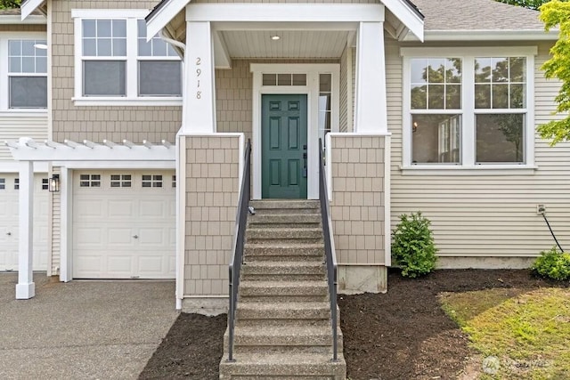 view of exterior entry with a garage and driveway