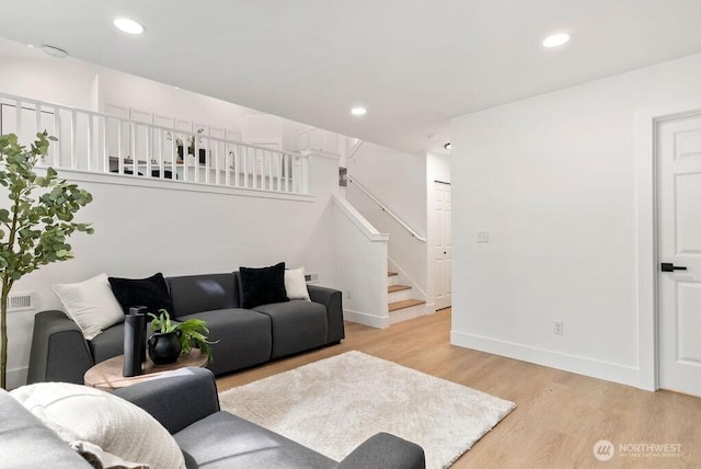 living room with stairs, light wood-type flooring, baseboards, and recessed lighting