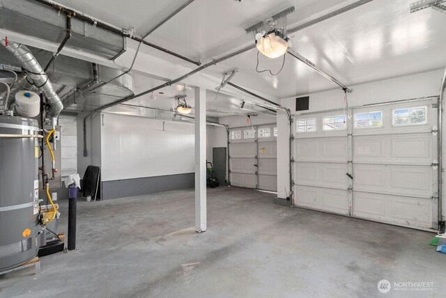 garage with strapped water heater and a garage door opener