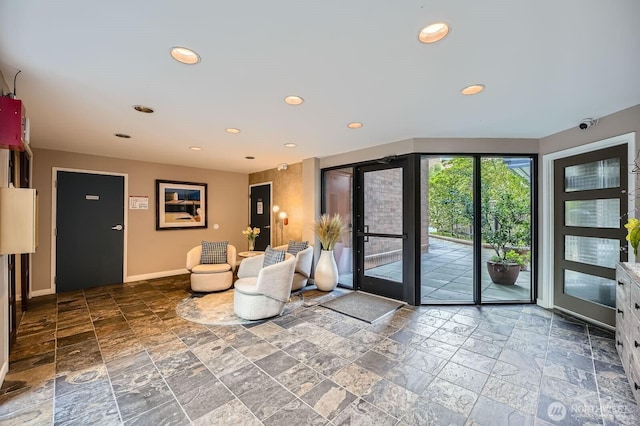 doorway with stone tile flooring, recessed lighting, and baseboards