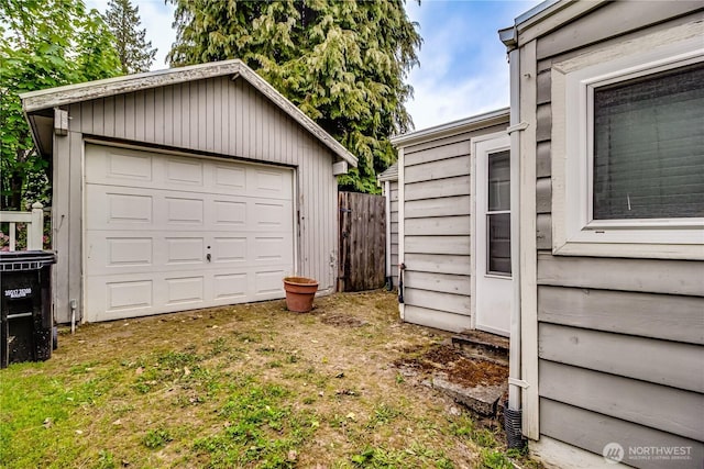 detached garage with fence and driveway
