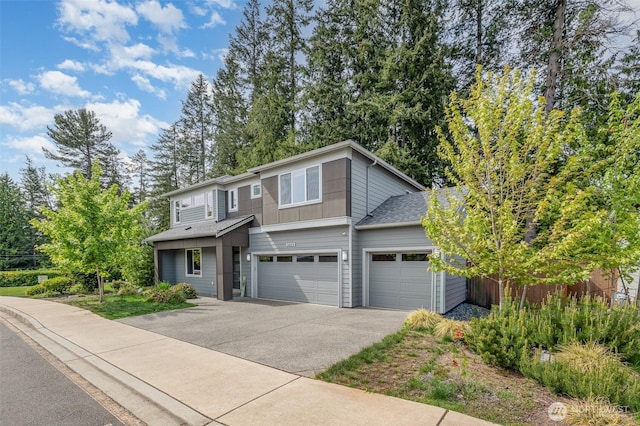 view of front of house featuring driveway, an attached garage, and roof with shingles