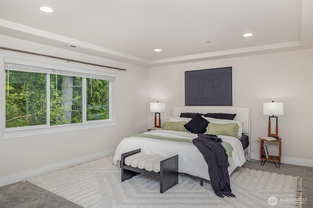 bedroom featuring baseboards, light colored carpet, a tray ceiling, and recessed lighting