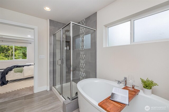 full bathroom featuring ensuite bathroom, a stall shower, a soaking tub, recessed lighting, and wood finished floors