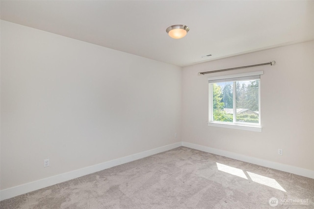 carpeted spare room with baseboards