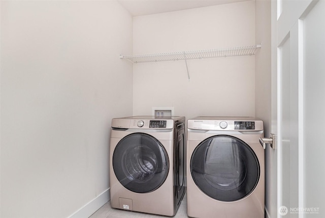 laundry room featuring separate washer and dryer, baseboards, and light tile patterned floors