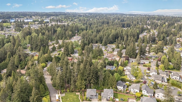 view of property location featuring a forest and nearby suburban area