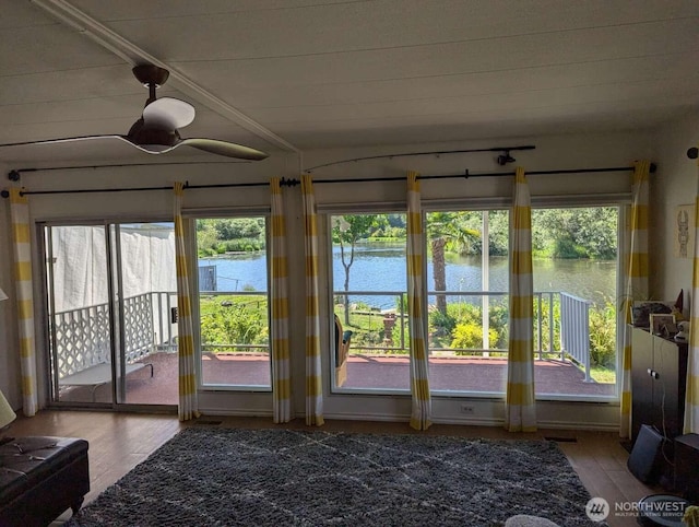 sunroom featuring a water view