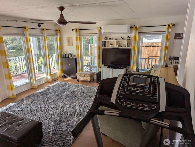 living area with an AC wall unit and a ceiling fan