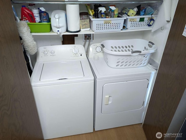 laundry room with washer and dryer and wood finished floors