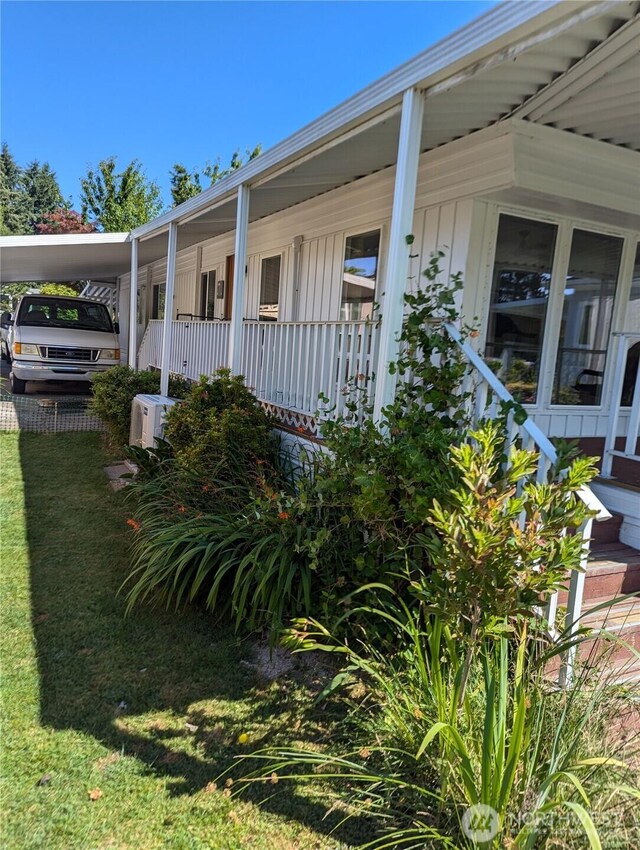 7301 NE 175th St Unit 140, Kenmore, WA 98028 - view of home's exterior with board and batten siding, a yard, and a carport