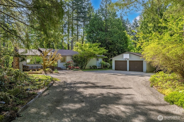 single story home with an outbuilding and asphalt driveway