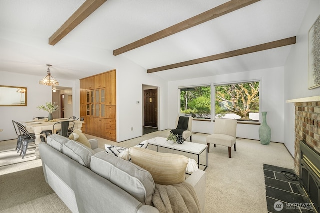 carpeted living room with a fireplace and a chandelier