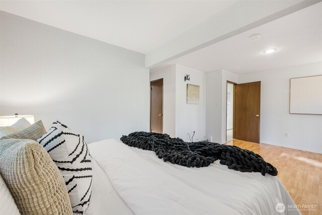 bedroom featuring light wood finished floors and baseboards