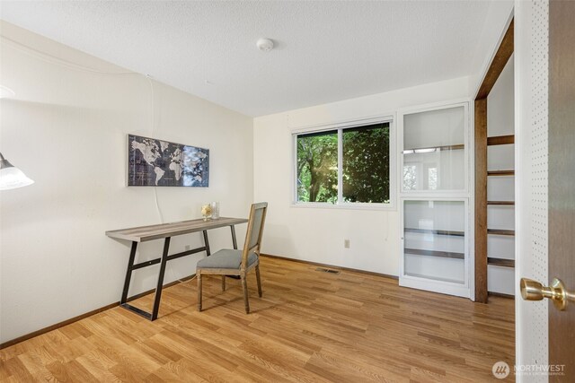 office space with wood finished floors and baseboards