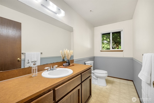 bathroom featuring toilet, vanity, tile patterned floors, and baseboards