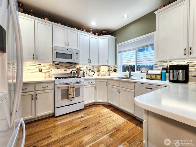 2332 130th Pl SE, Everett, WA 98208 - kitchen with white appliances, a sink, tasteful backsplash, light wood-style flooring, and light countertops