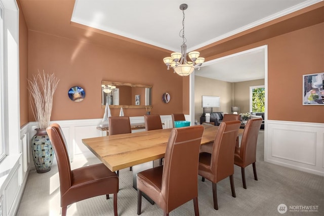 9437 NE Coral Ct, Bainbridge Island, WA 98110 - dining space with light colored carpet, a decorative wall, wainscoting, and a chandelier