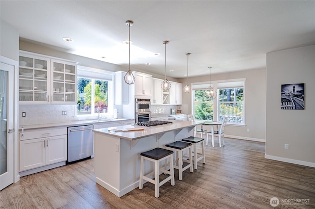 4213 Caddyshack Dr NE, Lacey, WA 98516 - kitchen featuring appliances with stainless steel finishes, backsplash, wood finished floors, white cabinetry, and light countertops