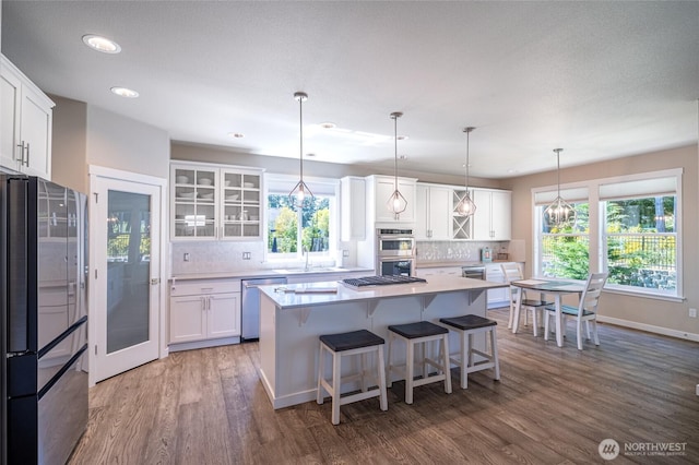 4213 Caddyshack Dr NE, Lacey, WA 98516 - kitchen featuring appliances with stainless steel finishes, wood finished floors, white cabinets, light countertops, and decorative backsplash
