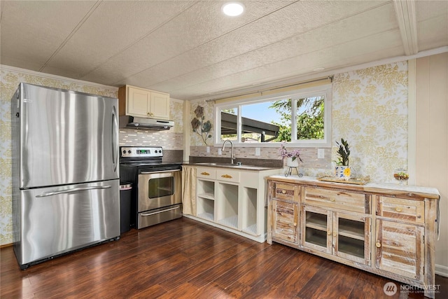 1921 208th St E Unit 9, Spanaway, WA 98387 - kitchen featuring appliances with stainless steel finishes, under cabinet range hood, a sink, dark wood-style floors, and wallpapered walls