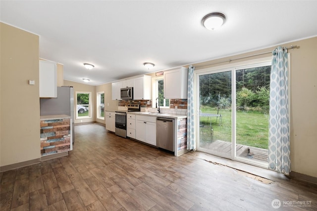 486 Justus Rd, Cinebar, WA 98533 - kitchen featuring stainless steel appliances, light countertops, white cabinetry, dark wood finished floors, and decorative backsplash