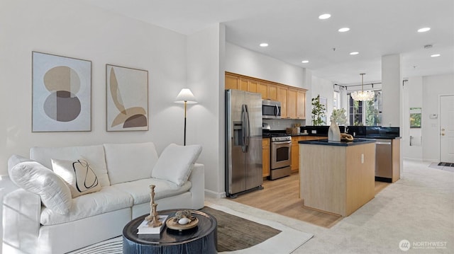 kitchen with stainless steel appliances, a kitchen island, open floor plan, dark countertops, and recessed lighting