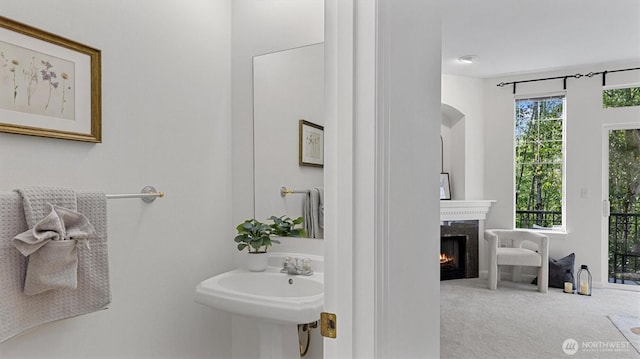 bathroom featuring a high end fireplace and a sink