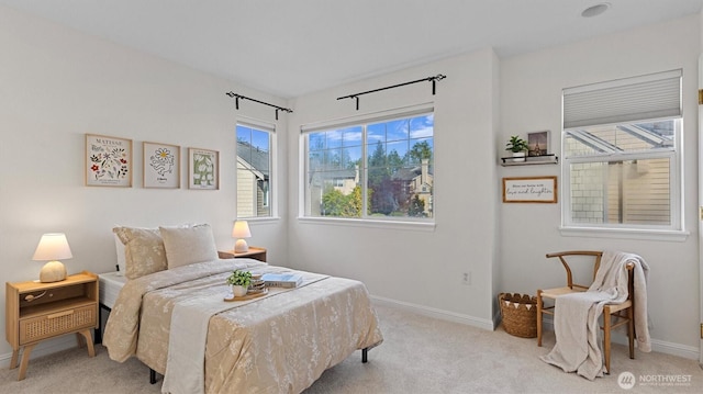 bedroom featuring light carpet and baseboards