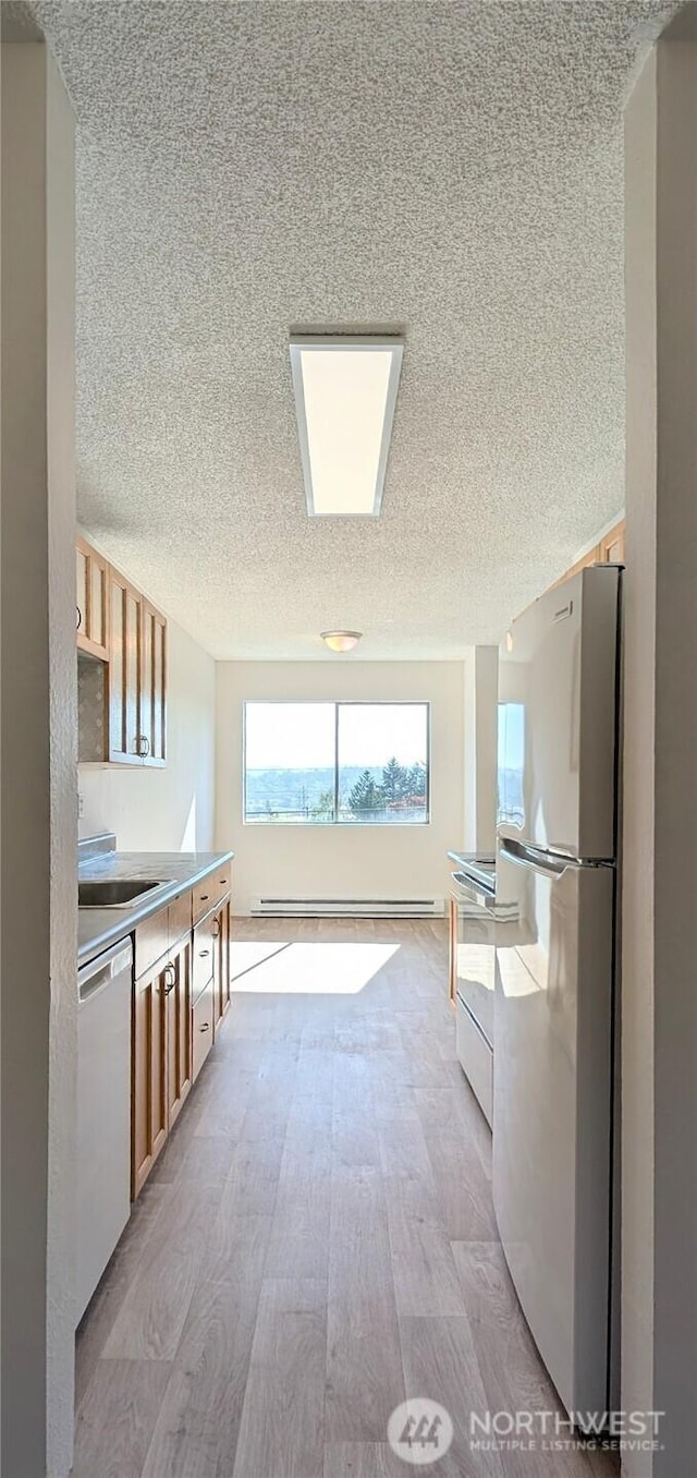 10459 Des Moinesmemorial Dr S Unit N-301, Seattle, WA 98168 - kitchen with freestanding refrigerator, dishwashing machine, a textured ceiling, stainless steel electric range oven, and light wood-style floors