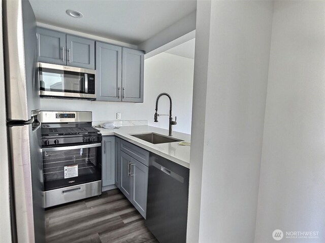 408-410 E 4th St, Warden, WA 98857 - kitchen featuring appliances with stainless steel finishes, a sink, gray cabinets, dark wood finished floors, and light countertops