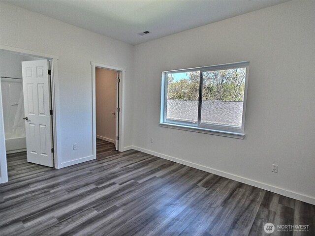 408-410 E 4th St, Warden, WA 98857 - unfurnished bedroom featuring dark wood finished floors, baseboards, a walk in closet, and connected bathroom
