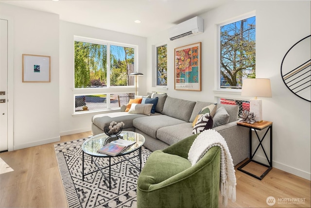 living room with a wall mounted air conditioner, wood finished floors, baseboards, and recessed lighting