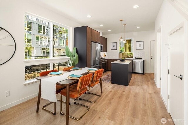 dining room with light wood-style flooring, recessed lighting, baseboards, and a chandelier