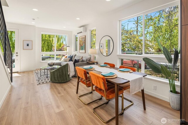 dining space with a wall mounted AC, light wood-type flooring, baseboards, and recessed lighting