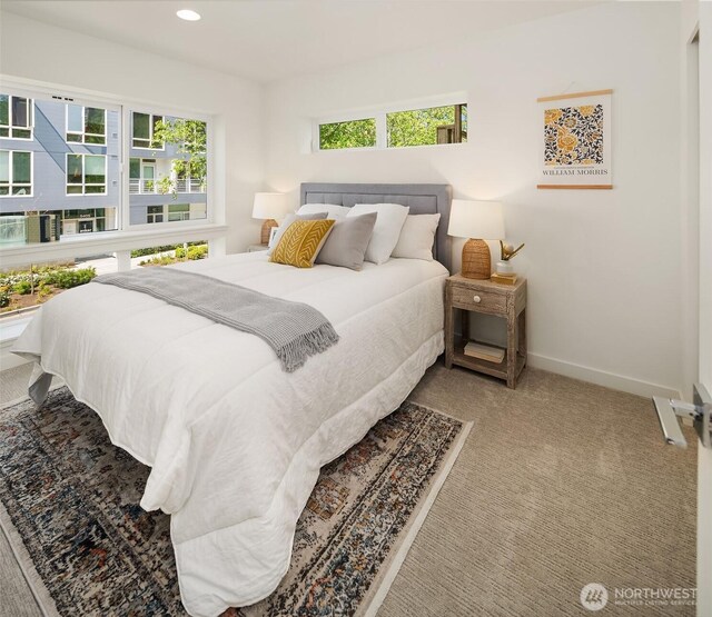 carpeted bedroom featuring baseboards and recessed lighting