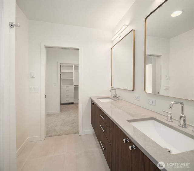 full bath with baseboards and double vanity