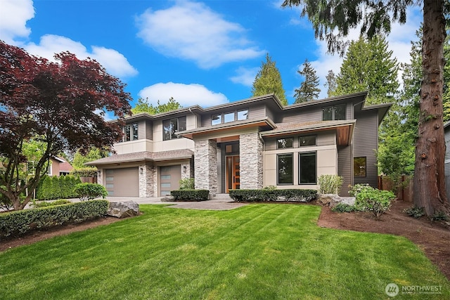 prairie-style house with an attached garage, stone siding, and driveway
