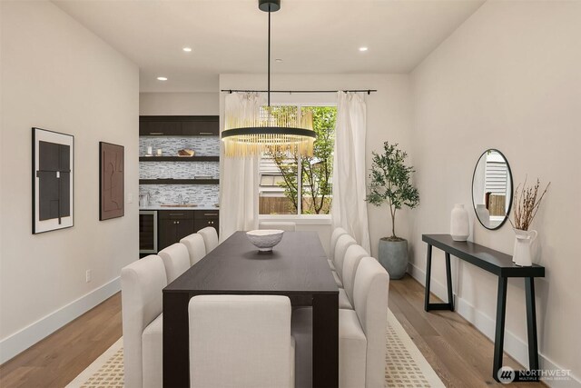 dining space featuring a chandelier, wood finished floors, electric panel, baseboards, and recessed lighting