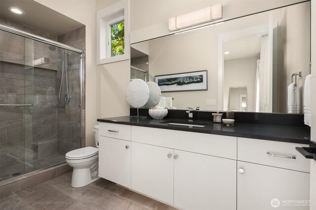 bathroom with a shower stall, toilet, vanity, and recessed lighting