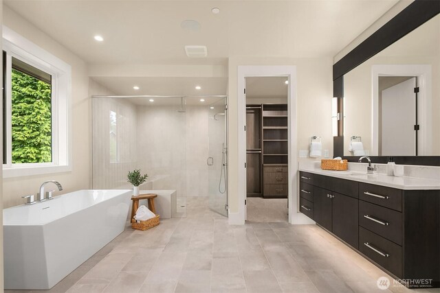 full bath with a shower stall, a soaking tub, vanity, recessed lighting, and tile patterned floors