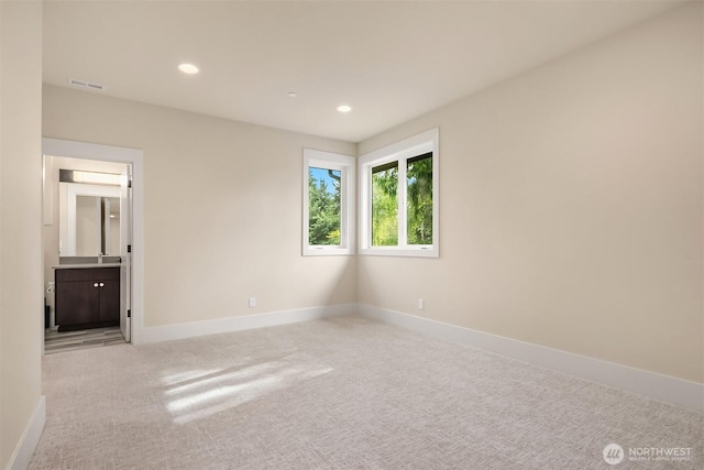 unfurnished bedroom with carpet floors, baseboards, recessed lighting, and ensuite bathroom