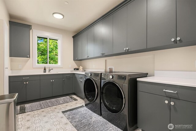 laundry room featuring washing machine and clothes dryer and cabinet space