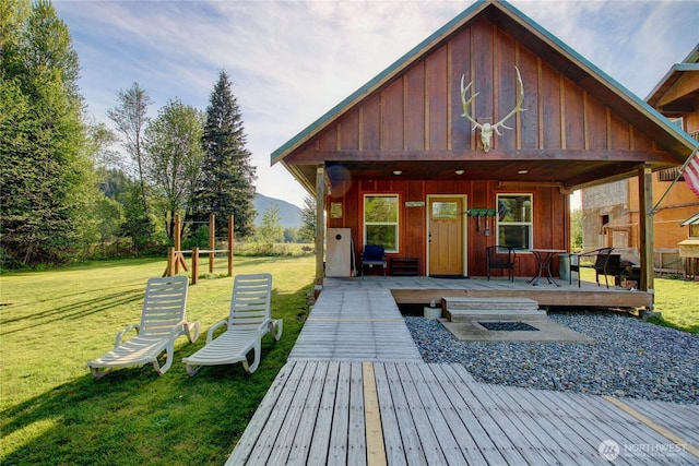 53932 Rockport Cascade Rd, Rockport, WA 98283 - view of front of house featuring board and batten siding, a front yard, a wooden deck, and an outdoor structure