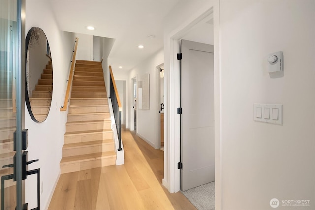 stairs with wood finished floors and recessed lighting