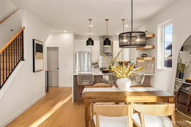 dining area with light wood-style floors, recessed lighting, stairway, and baseboards