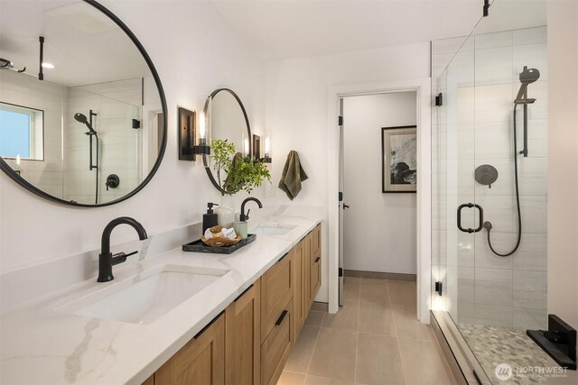 full bathroom featuring a stall shower, tile patterned flooring, and double vanity